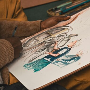 Close-up of an artist drawing a historical scene on paper with colored pencils.